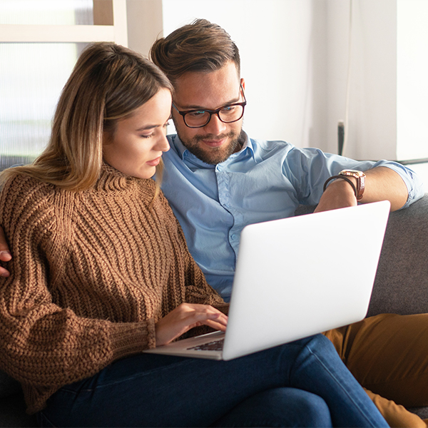 Happy couple shopping on their computer
